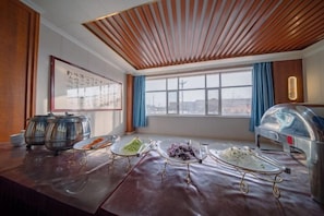 A room with a buffet setup, a large window with a view, and a ceiling with wooden slats. - Jingyugong Hotel (Jingtai)
