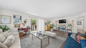 Een moderne woonkamer met een bank, een salontafel, een televisie en een bureau.
