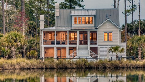 A two-story house with a balcony and a reflection in the water. - Lake Views  + Porch Movies, Game Nights and Hot Tub (Bluffton)
