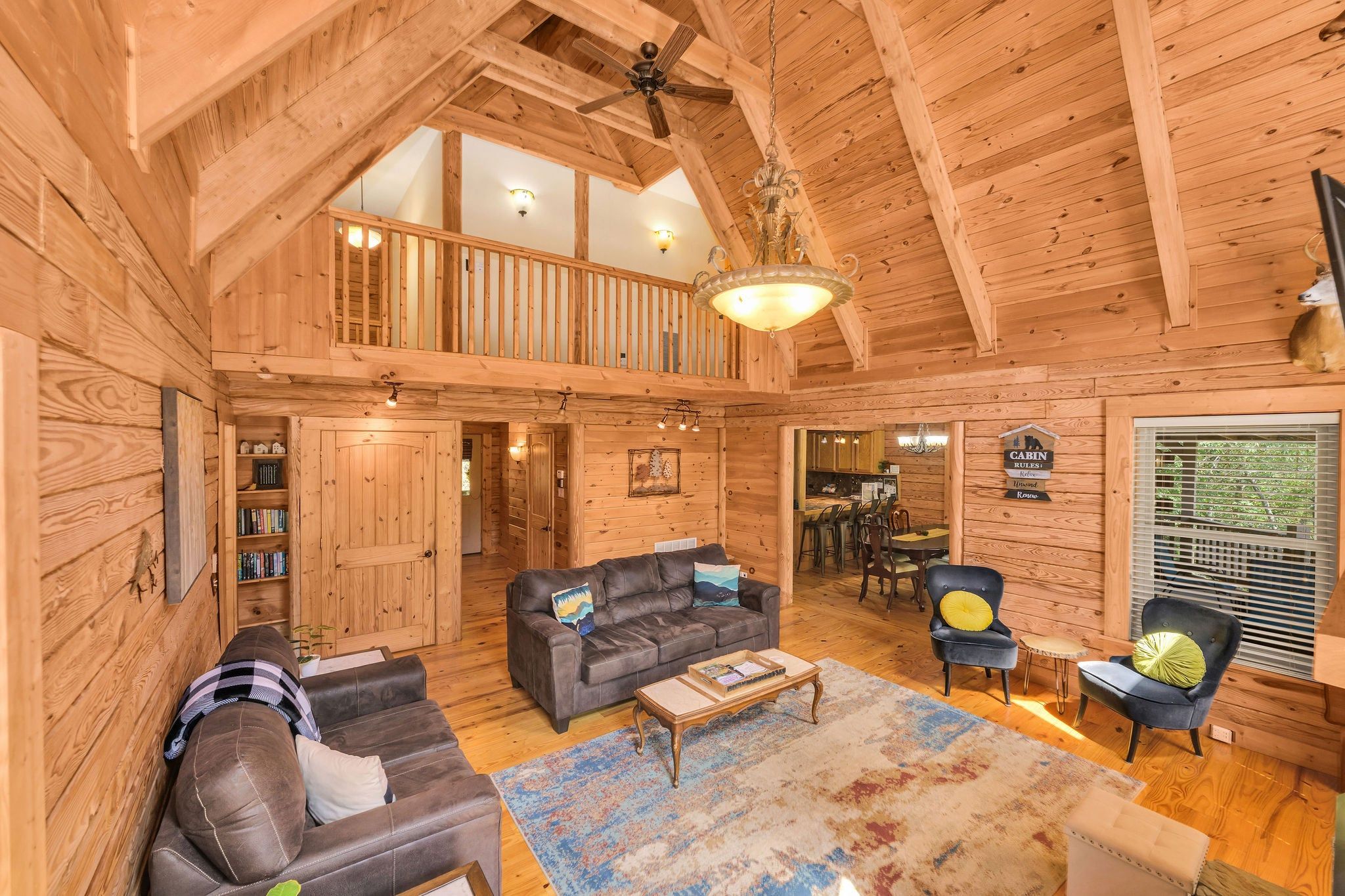 L’intérieur d’une cabane comprend une chambre à coucher située en mezzanine, un coin repas et un salon aménagé avec des canapés en cuir et une table basse.