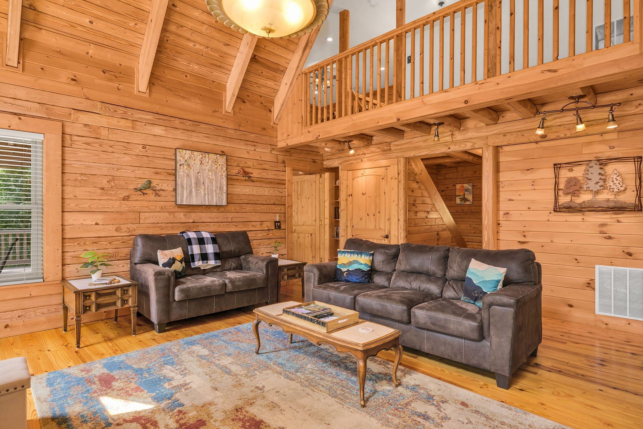 A wooden interior with two sofas, a coffee table, and a staircase.