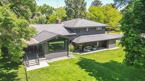 A two-story house with a covered patio, large windows, and a well-maintained lawn. - Pets & Kids Love this Montana Dream Home! (Billings)