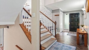 A staircase with wooden railings and beige carpeted steps leading to a landing. - Pets & Kids Love this Montana Dream Home! (Billings)