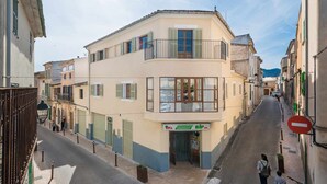 Una calle estrecha flanqueada por edificios, con un supermercado a la vista y un paso de peatones.