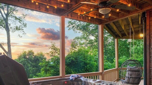 A hot tub on a wooden deck with a view of trees and a sunset. - Experience North GA Mtn Retreat: Views w/ Hot Tub (Morganton)