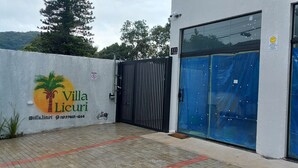 A gated entrance to Villa Licuri with a palm tree logo, a no parking sign, and a contact number. - Duplex apartment in Villa Licuri (são sebastião)