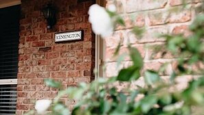 Un edificio de ladrillo con un letrero que dice "Kensington" y una ventana con persianas.