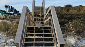 A wooden staircase leading to a beach area with a sign indicating it is for 'SEASPRAY OWNERS ONLY'.