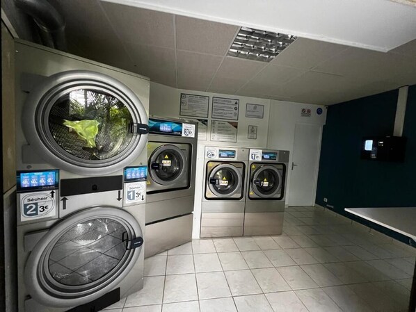 Eine Waschsalon mit mehreren Waschmaschinen, einer digitalen Anzeige und einem gefliesten Boden.