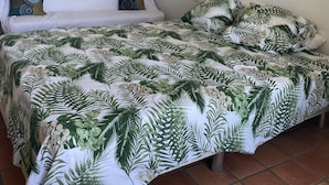 Ein Schlafzimmer mit Bett, Spiegel, Wandleuchten und einem Wandbild.