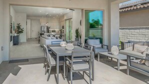 A modern kitchen with a dining area, large windows, and a ceiling fan. - Private pool & hot tub w/ mountain views (La Quinta)