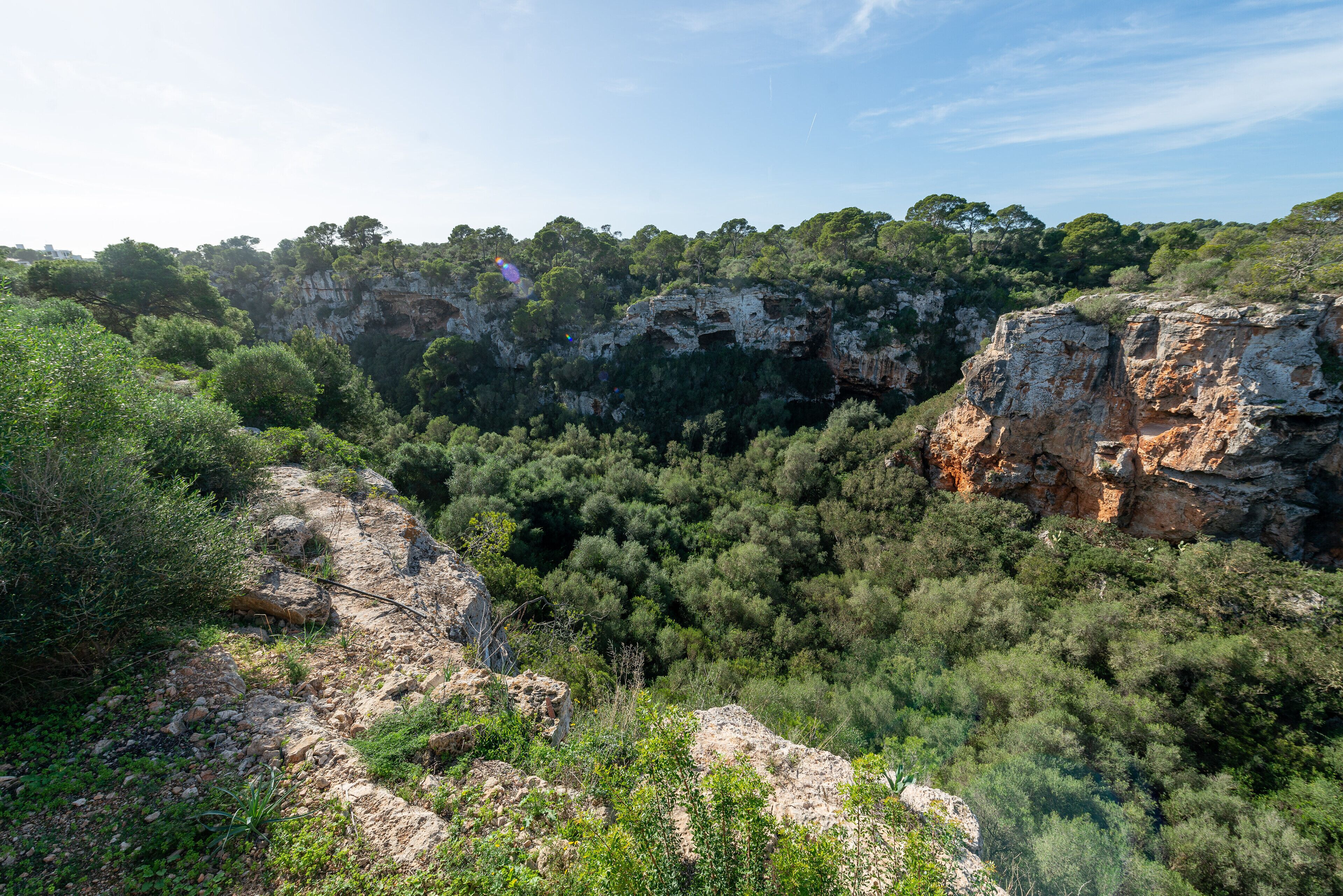 A natural landscape with rocky cliffs and dense greenery.