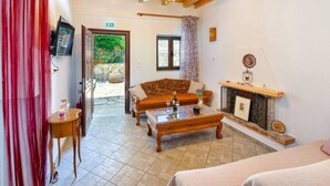 A room with a sofa, a coffee table, a fireplace, and a television. - Holiday Home 'Ria Sweet Home Paxos' with Private Terrace, Private Garden and Wi-Fi (Corfu)