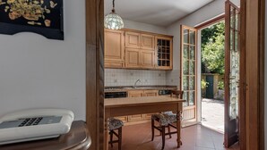 A kitchen with wooden cabinets, a tiled backsplash, a central island, and a telephone on a wooden table. - Holiday Home 'Gigli Di Firenze' with Mountain View, Wi-Fi and Air Conditioning (Rufina)