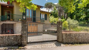 A house with a stone gate, a balcony, and a garden. - Holiday Home 'Gigli Di Firenze' with Mountain View, Wi-Fi and Air Conditioning (Rufina)