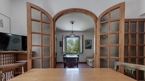 A dining area with a wooden table and chairs, a television, and a view through a glass door to an outdoor area. - Holiday Home 'Gigli Di Firenze' with Mountain View, Wi-Fi and Air Conditioning (Rufina)