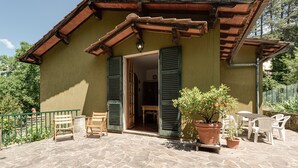 A building with a stone patio, wooden furniture, and potted plants. - Holiday Home 'Gigli Di Firenze' with Mountain View, Wi-Fi and Air Conditioning (Rufina)