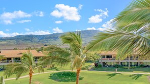 A resort with a view of mountains, palm trees, and a well-maintained lawn. - Maui Resort Rentals: Honua Kai Konea 308 - Spacious  2BR/1BA, Gorgeous Partial Ocean and Lush West Maui Mountain Views! (Lahaina)