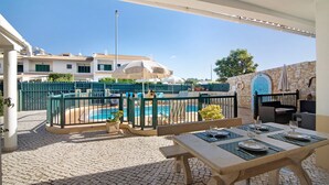 A patio area with a pool, outdoor seating, and a dining table set for two. - "Villa Catarina" Vacation Home with Pool & Wi-Fi (Albufeira)