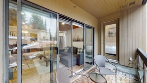 A modern interior with a glass door leading to a living area, a sofa, and a dining table. - Ironwoods Blueberry Hill by Whistler VR (Whistler)