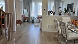 Un'ampia zona giorno con tavolo da pranzo, sedie e un grande specchio che riflette l'ambiente.