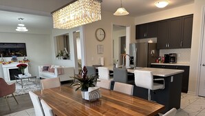Una cucina moderna con mobili scuri, un frigorifero in acciaio inossidabile e una macchina per il caffè.
