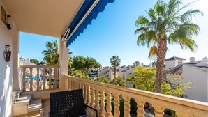 A balcony with a stone balustrade, a black chair, and a patterned cushion. - Holiday Apartment "Sunnygolfbeach" with Shared Pool, Terraces & Wi-Fi (Orihuela Costa)