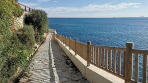 A stone pathway leading to a wooden railing overlooking a body of water. - Holiday Apartment "Sunnygolfbeach" with Shared Pool, Terraces & Wi-Fi (Orihuela Costa)