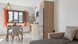 A modern kitchen with a dining area, a sofa, and a window with curtains. - Holiday Home "Casa Lía" with Wi-Fi (La Santa)
