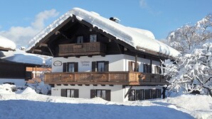 Ein zweistöckiges Gebäude mit einem Balkon, umgeben von Schnee.