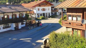 Ein traditionelles europäisches Dorf mit Kopfsteinpflasterstraßen, Holzhäusern und einer Bergkulisse.