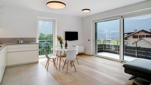 Een moderne keuken met een eethoek, grote schuifdeuren en een flatscreen televisie.