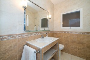 Ein Badezimmer mit Waschbecken, Spiegel und Toilette.