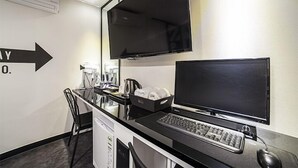 A hotel room with a desk, a flat-screen TV, a computer, and a coffee machine. - Gunsan Hotel Box (Gunsan)