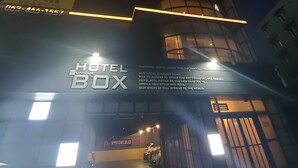 A hotel building with illuminated signage, a grand open entrance, and a visible parking area with cars. - Gunsan Hotel Box (Gunsan)