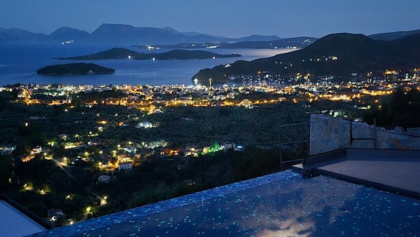 Una piscina en la azotea con vistas a un paisaje urbano al atardecer.