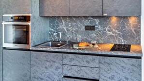 Una cocina moderna con horno empotrado, salpicadero de mármol y encimera elegante.