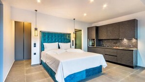 Un dormitorio moderno con una cama grande, armario empotrado y una kitchenette.