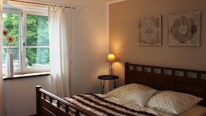 Une chambre à coucher comprenant un lit, une table de chevet, une lampe et deux éléments décoratifs fixés au mur.