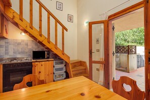 A kitchen with wooden cabinets, a microwave, and a stove.