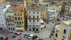 Un edificio de varios pisos con un patio central, balcones y un espacio comercial en la planta baja.