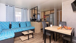 A modern kitchenette with a microwave, refrigerator, and wooden cabinets. - Holiday Apartment "Mobile-home Alain" with Garden & Terrace (Saint-Julien-en-Born)
