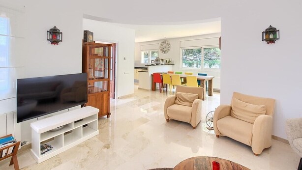 Una sala de estar moderna con televisor, sofá y mesa de centro.