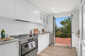 Enjoy cooking in this well-equipped kitchen with an oven and microwave, and take in the view of the patio and lush surroundings.