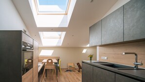 Una cocina moderna con tragaluces, comedor y zona de juegos para niños.