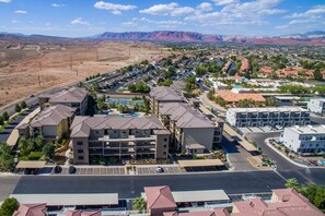 A residential area with a large building featuring multiple floors and a swimming pool.