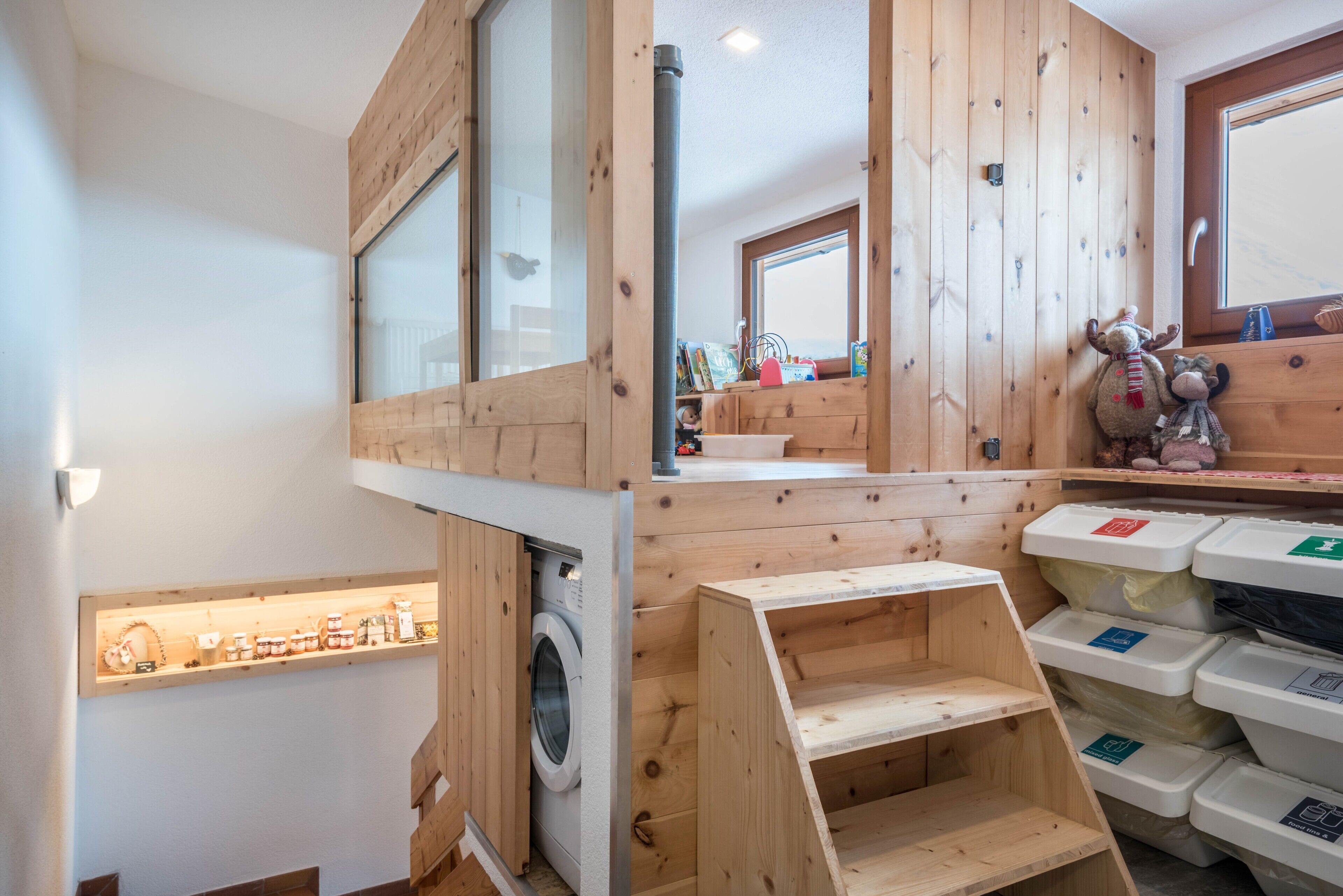 Ein Zimmer mit Holzwänden, einer Waschmaschine und Aufbewahrungsbehältern.