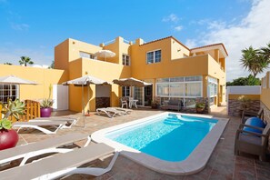 A residential property with a swimming pool, lounge chairs, and outdoor furniture. - Vacation Home "Casa Paco 3" with Sea View, Private Terrace & Shared Pool (Costa Calma)