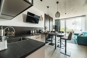 Kjøleskap, espressomaskin, vannkoker og høy barnestol