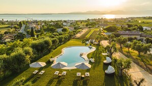 Un complexe hôtelier doté d’une piscine, de chaises longues et de parasols.